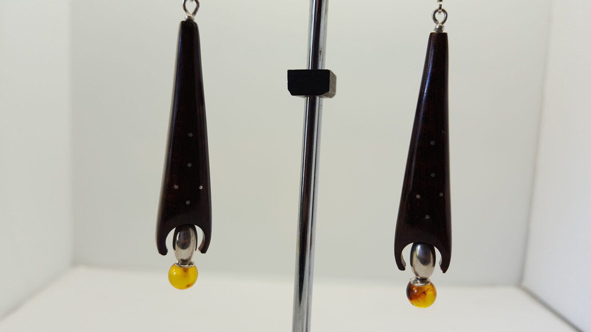 boucles fusée amourette ; BO amourette en forme de fusée . Dans son cercle en bas se logent une olive argent et une perle en ambre . Attaches dormeuses ; elles sont suspendues sur leur présentoire