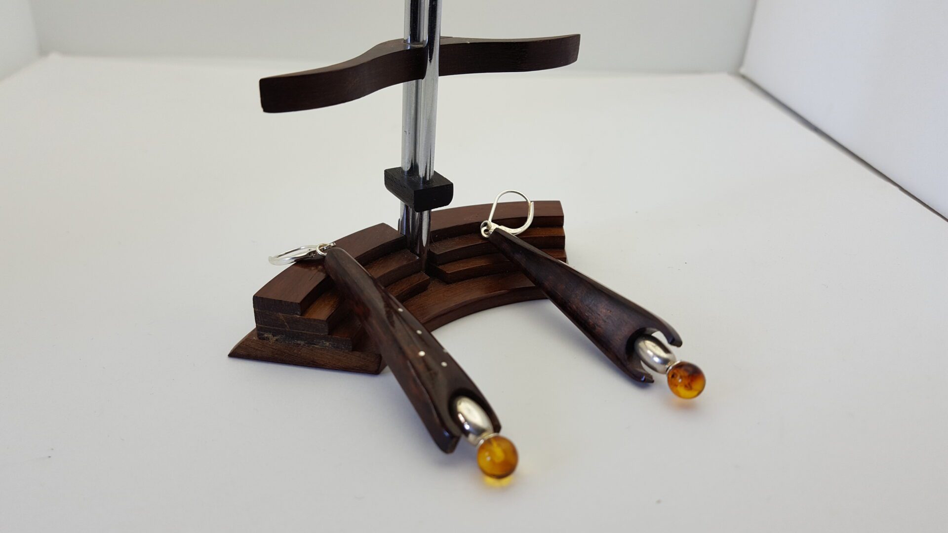 BO amourette en forme de fusée . Dans son cercle en bas se logent une olive argent et une perle en ambre . Attaches dormeuses .