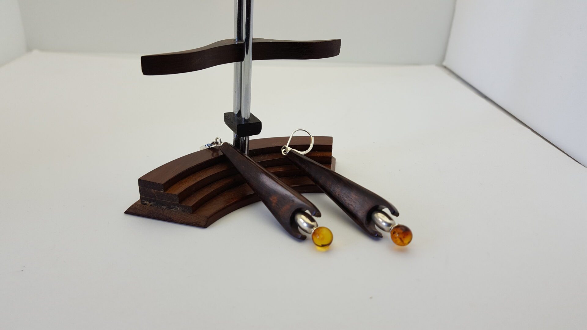 Boucle d'oreille forme fusée . Axe bois d'amourette , olive argent et perle ambre attache dormeuses argent .