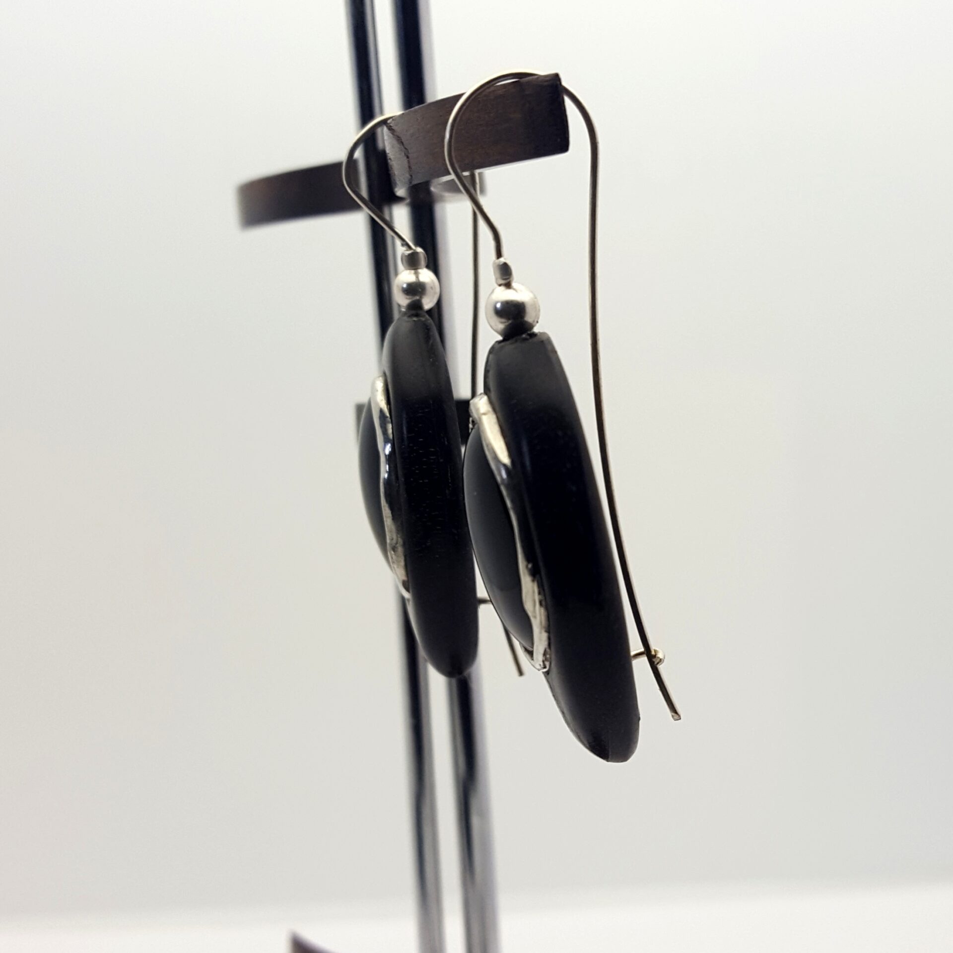 boucles d'oreilles pendantes . Onyx serti d'étain encastré dans un ovale d'ébène . Attache argent . vu de profil .